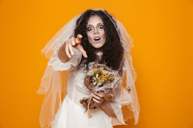 Görüntü ürkütücü gelin zombi korkunç makyaj sarı arka plan üzerinde izole kamera gülümseyen ve gelinlik giyen Halloween