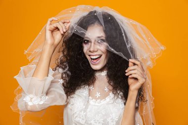 Sarı arka plan üzerinde izole korkunç zombi kadının fotoğrafını Cadılar Bayramı giyen gelinlik ve tatil makyaj dokunmadan beyaz peçe