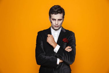 Yakışıklı adam zombie halloween makyaj görünümlü kamera üzerinde orange ciddiye izole ile