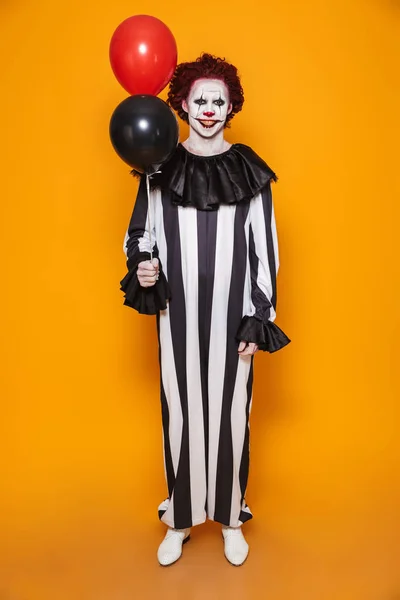 Largura Completa Sonriente Hombre Espeluznante Payaso Mirando Cámara Sosteniendo Globos —  Fotos de Stock