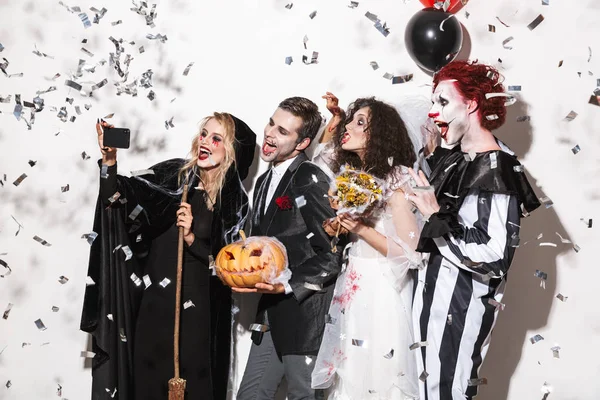 Group Smiling Friends Dressed Scary Costumes Celebrating Halloween Confetti Rain — Stock Photo, Image