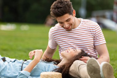 Görüntü bir sevgi dolu iki adam ve kadın 20'li yaşlarda uzanan ve park yeşil çim üzerinde yalan