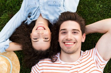 Mutlu çift erkek ve kadın 20'li yaşlarda üstünden görüntü yanında park yeşil çimenlerin üzerinde ters kafa yalan