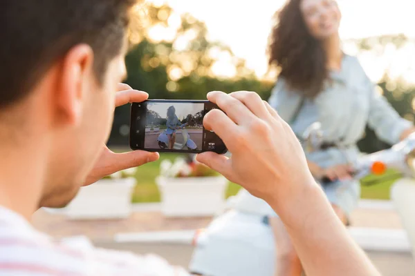 Foto Joven Fotografiando Novia Teléfono Móvil Mientras Ella Está Sentada — Foto de Stock