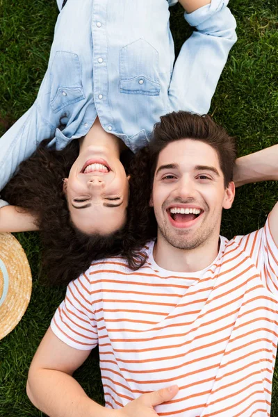 Üst çift erkek ve kadın 20'li yaşlarda görüntüden Park yeşil çimenlerin üzerinde ters kafa yanında yalan