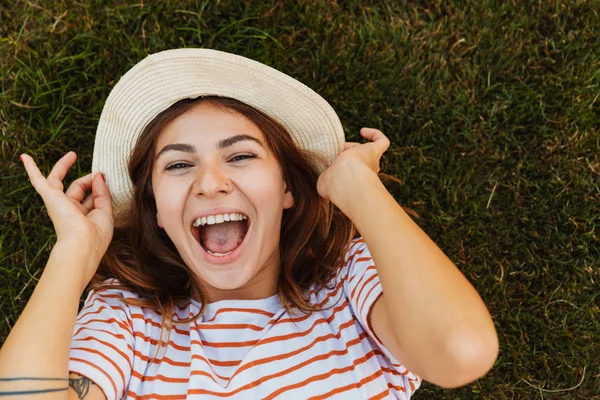 Ovanifrån Glad Ung Flicka Sommar Hatt Handpåläggning Ett Gräs Grimaserande — Stockfoto