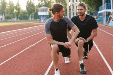 Açık havada germe egzersizleri yapmak imge-in yakışıklı genç iki ikiz kardeşler sporcuların.