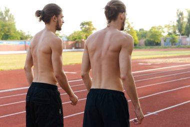 Genç iki ikiz sporcular kardeşler açık havada Stadı nda görünüm görüntüsünü geri.
