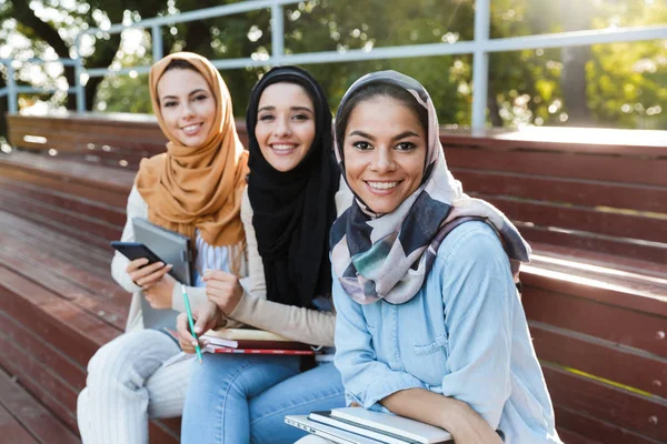 Foto Jovens Mulheres Islâmicas Vestindo Lenços Cabeça Sentado Banco Parque — Fotografia de Stock