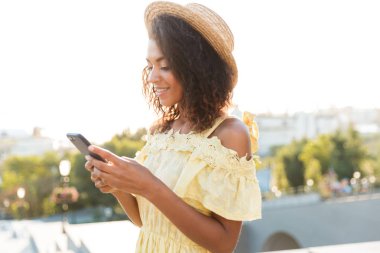 Cep telefonunuzun ve açık havada yürüyen Afrika genç kadın görüntüsünü.
