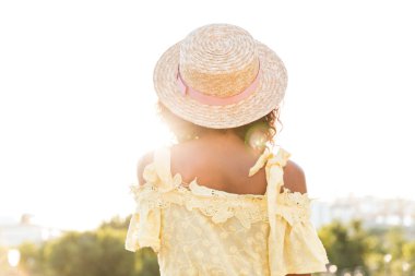 Açık havada yürüyüş güzel güneş ışığı ile Afrika genç kadının fotoğrafını görünümü geri.