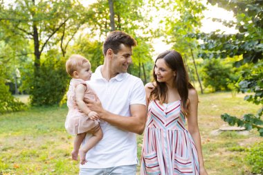 Kızla yürüyüşe sahip parkta, birlikte vakit küçük bebek neşeli genç Aile