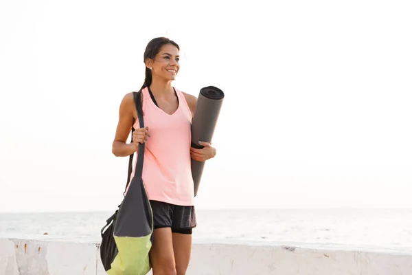 Happy Young Sportswoman Holding Fitness Mat Standing Outdoors Seaside — Stock Photo, Image