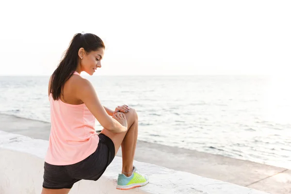 Foto Slim Kaukasiska Idrottskvinna 20S Träningsoverall Stretching Benen Träning Seaside — Stockfoto