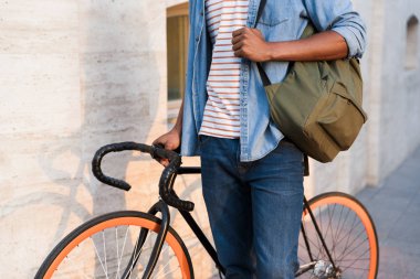Bisiklet ile açık havada sokakta dolaşan genç Afrika adam fotoğraf kırpılmış.