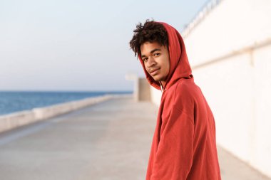 Genç bir görüntüsünü Afrika adam açık havada kamera seyir sahilde spor.