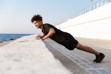 Sahilde açık havada egzersiz yapmak imge-in yakışıklı genç adam sporcu.