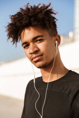 Kulaklık ile müzik dinlemek plajda durup genç Afrika genç bir yakın çekim