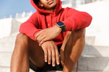 Açık havada oturma, akıllı saati hoodie Afrikalı adamın resim kırpılmış