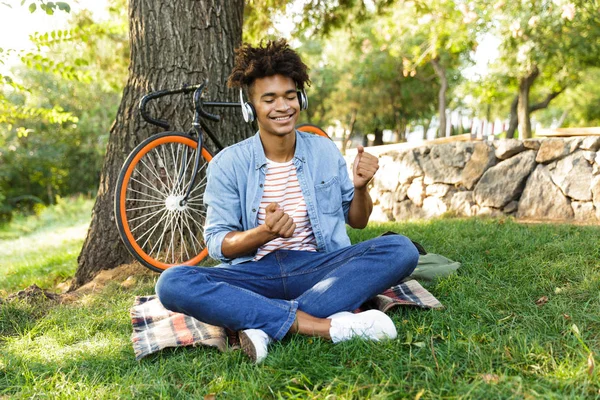 Jovem Adolescente Africano Alegre Com Bicicleta Livre Sentado Grama Ouvindo — Fotografia de Stock