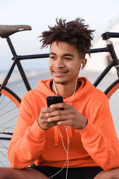 Snímek Mladé Sportovní Chlap Venku Pláži Kol Pomocí Mobilního Telefonu — Stock fotografie