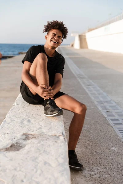 Imagem Jovem Desportista Triste Sentado Com Dor Perna Livre Praia — Fotografia de Stock