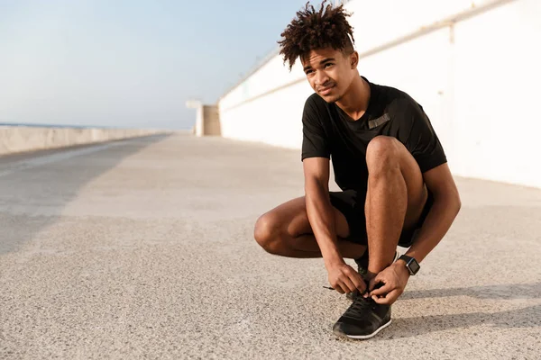 Strong Young African Man Dressed Sportswear Tying His Shoelace Beach — Stock Photo, Image