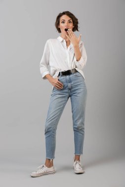 Görüntü gri duvar arka plan üzerinde izole poz heyecanlı sürpriz genç iş kadını.