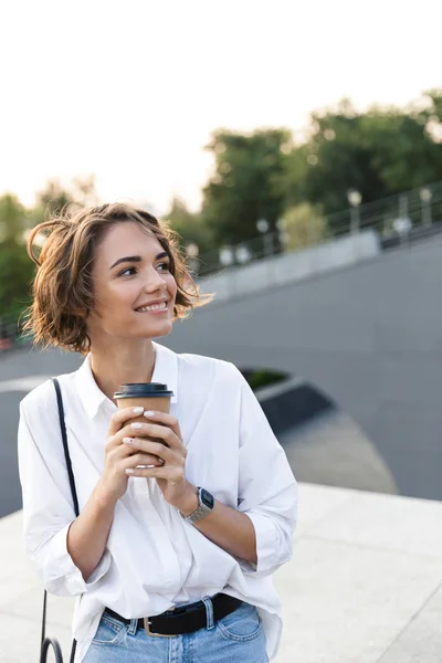 Atractiva Joven Mujer Pie Calle Sosteniendo Una Taza Café Mirando —  Fotos de Stock