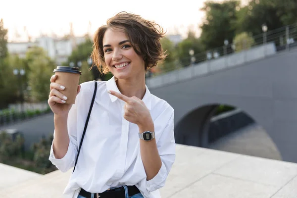 Atractiva Joven Mujer Pie Calle Mostrando Una Taza Café —  Fotos de Stock