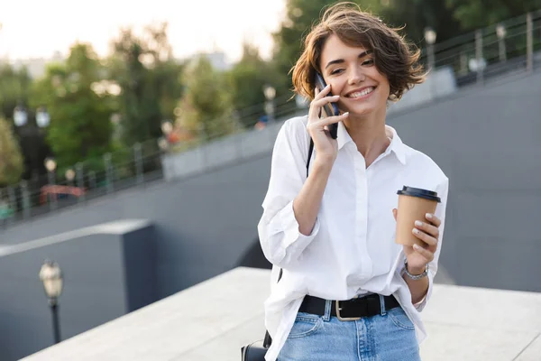 Привлекательная Молодая Женщина Стоящая Улице Держа Чашку Кофе Разговаривая Мобильному — стоковое фото
