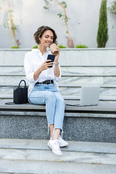 Mujer Joven Sonriente Con Auriculares Sentados Aire Libre Calle Hablando —  Fotos de Stock