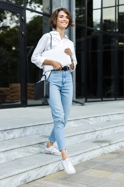 Joven Mujer Alegre Caminando Aire Libre Calle Llevando Ordenador Portátil —  Fotos de Stock