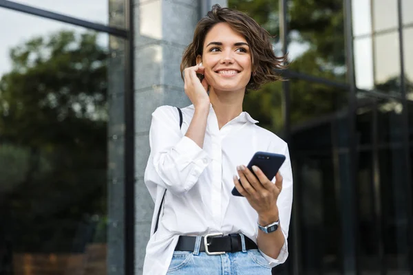 Gelukkig Jonge Vrouw Oortelefoons Permanent Buiten Straat Praten Mobiele Telefoon — Stockfoto