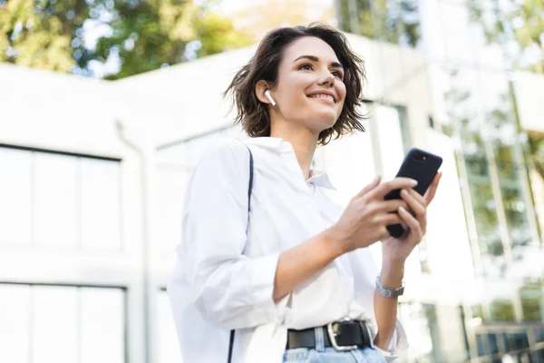 Krásná Mladá Žena Sluchátka Stojící Venku Ulici Pomocí Mobilního Telefonu — Stock fotografie