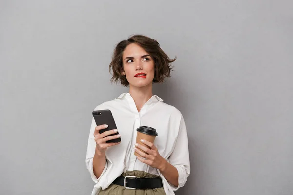 Фото Привлекательной Женщины Кофе Вынос Использование Мобильного Телефона Изолированы Сером — стоковое фото