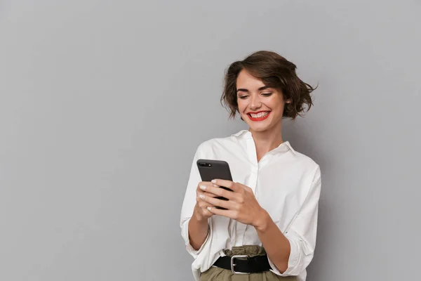 Photo Caucasian Woman 20S Smiling Holding Mobile Phone Isolated Gray — Stock Photo, Image