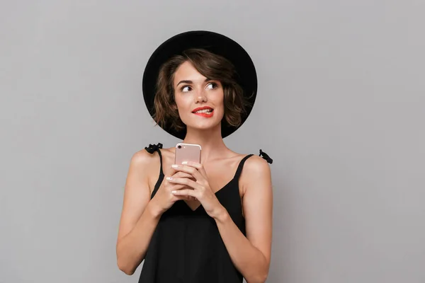 Фото Симпатичной Женщины Лет Черном Платье Шляпе Улыбающейся Камеру Держа — стоковое фото