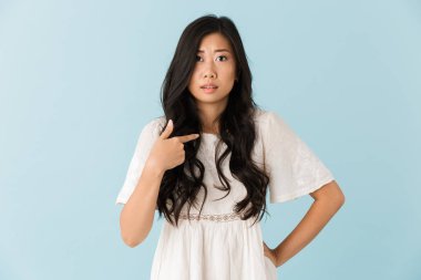 Genç sinir Asyalı güzel kadın mavi arka plan işaret içinde izole görüntüsünü.