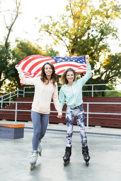 愉快的二个女孩朋友姐妹的图片在公园外面的滚轮举着 Usa — 图库照片