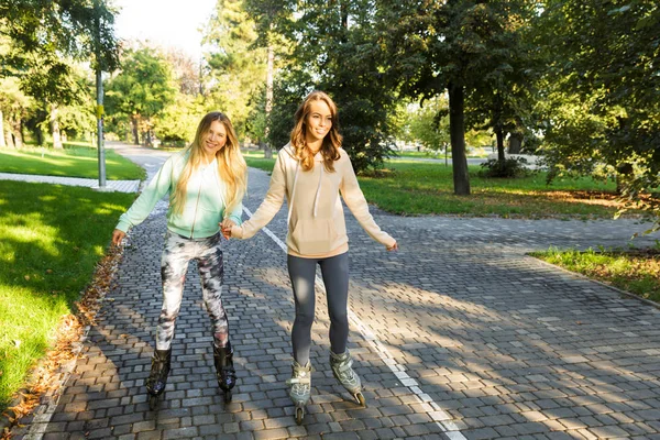 Duas Jovens Garotas Alegres Patins Passando Tempo Parque Mãos Dadas — Fotografia de Stock