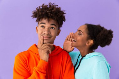 Kulak yakışıklı adamın menekşe arka plan üzerinde izole konuşan genç Afro-Amerikan kadın fotoğrafı