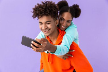 Selfie kardeşim menekşe arka plan üzerinde izole arkadan sarılma süre alarak güzel Afrikalı-Amerikalı kadın fotoğrafı