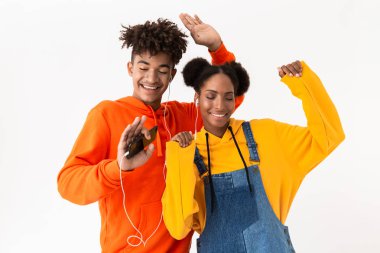 Fotoğraf genç Afro-Amerikan çift renkli giysileri beyaz arka plan üzerinde izole kulaklık ile birlikte müzik dans