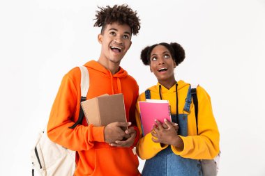 Egzersiz beyaz arka plan üzerinde izole kitap tutan sırt çantaları giyen neşeli Afro-Amerikan öğrenciler fotoğrafı