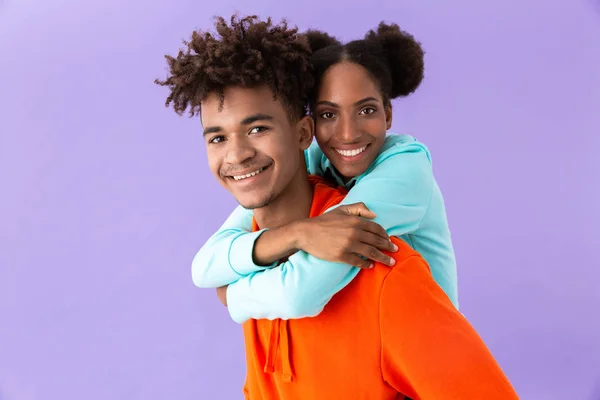 紫色の背景に分離された彼の笑みを浮かべて妹をピギーバック若いアフリカ系アメリカ人兄弟の写真 — ストック写真
