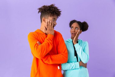 Sürpriz Afro-Amerikan ve çığlık ve menekşe arka plan üzerinde izole yüz dokunmadan kız fotoğrafı