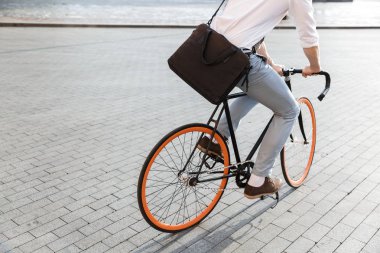 Fotoğraf genç adam caddenin üzerinde bisiklet sürme resmi giyim 30s