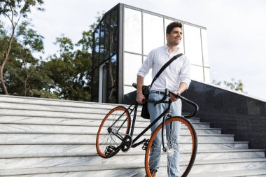 Aşağı gidiş neşeli işadamı bir bisiklet açık havada şehir Caddesi'nde taşıyan gömlek giymiş