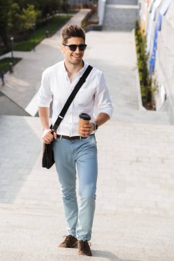 Üst katta açık havada yürüyüş şehir sokak paket servisi olan restoran kahve tutarak gömlek giymiş işadamı gülümseyen